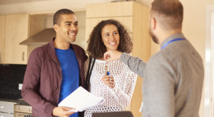 a young couple receive the keys to their new apartment from a letting agent.